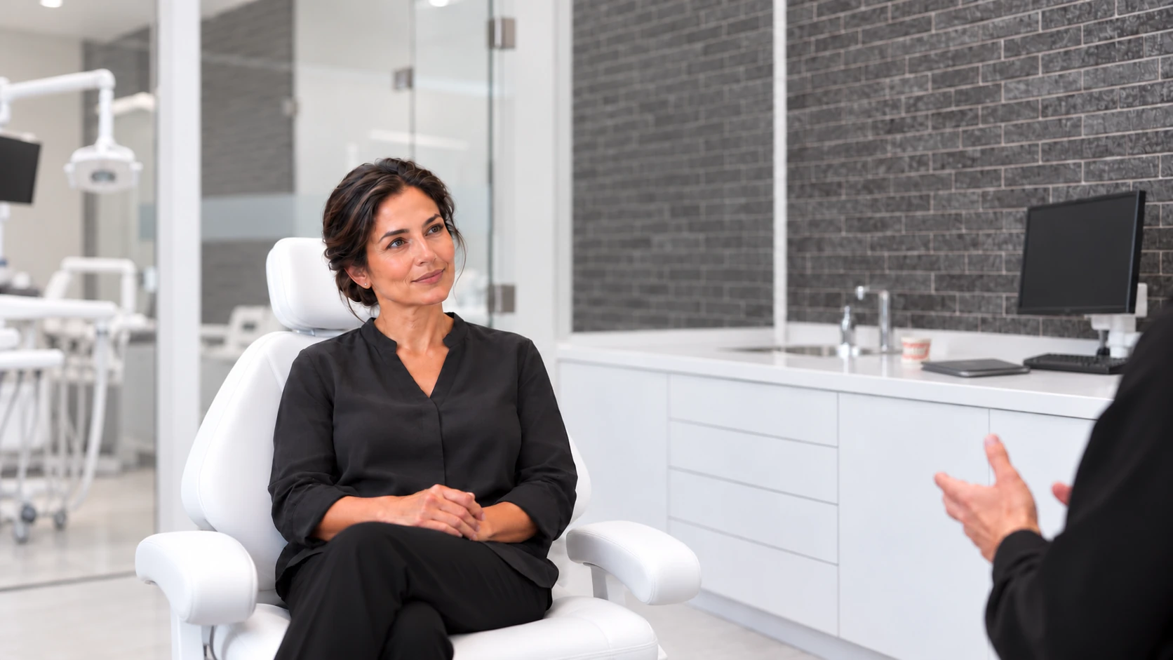 Woman in black seated in a white dental chair